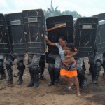 Woman and baby in Brazil running from soldiers.